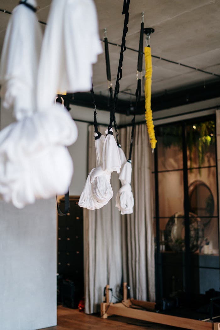 A contemporary interior of an aerial yoga studio featuring hanging hammocks and equipment.